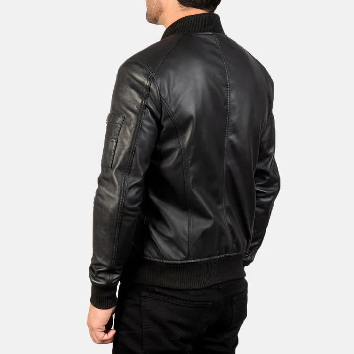 "Bomia MA-1 Black Leather Bomber Jacket by MordenJacket – a sleek reinterpretation of the classic MA-1 bomber, crafted in smooth black leather with ribbed cuffs, utility pocket on the sleeve, and a timeless silhouette for everyday edge."
back pose