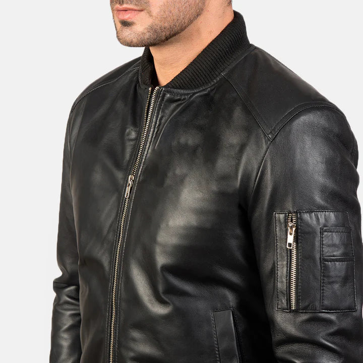 "Bomia MA-1 Black Leather Bomber Jacket by MordenJacket – a sleek reinterpretation of the classic MA-1 bomber, crafted in smooth black leather with ribbed cuffs, utility pocket on the sleeve, and a timeless silhouette for everyday edge."
side pose